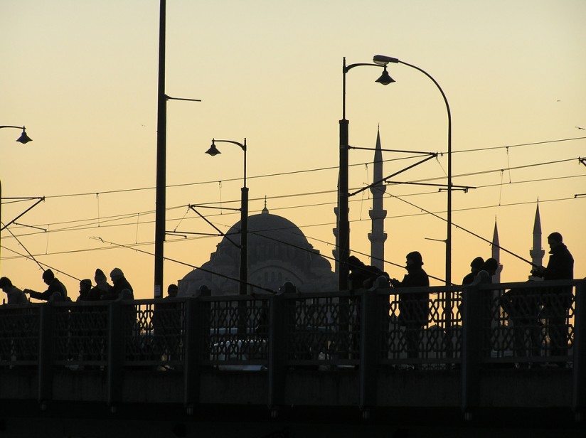 Au centre d'Istanbul, des hommes tentent le poisson avec leur canne à pêche sur le pont de Galata.